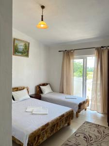 two beds in a room with a window at Kastrati Apartments in Ulcinj