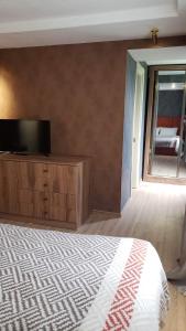 a bedroom with a bed and a flat screen tv at Lileo in Tsalka