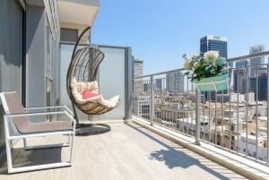 a balcony with two chairs and a view of a city at TLV Luxury Modern Apartment City Center in Tel Aviv