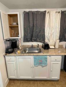 eine Küchentheke mit einem Waschbecken und einem Fenster in der Unterkunft Cozy Studio…With Private Entrance in Las Vegas
