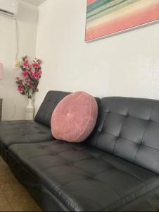 un divano in pelle nera con un cuscino rosa di Cozy Studio…With Private Entrance a Las Vegas