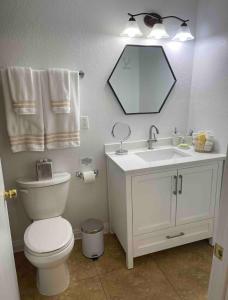 y baño con aseo, lavabo y espejo. en Cozy Studio…With Private Entrance en Las Vegas