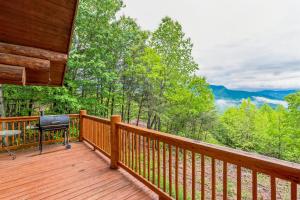 a wooden deck with a table and a grill on it at Royal Views - Private Mountain Top Cabin cabin in Gatlinburg