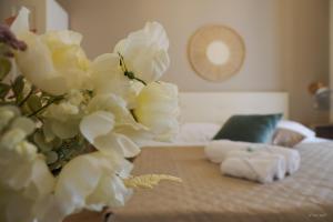 a bedroom with a bed with white towels and flowers at Alla Scaletta in Trapani