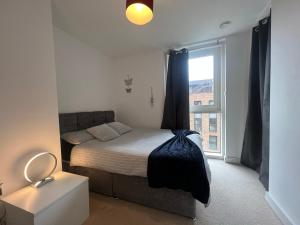 a small bedroom with a bed and a window at Modern 2BR 2BA Apt wParking Sleeps 6 Comfortably in London