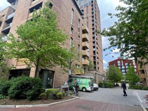 a green van parked in a parking lot next to buildings at Modern 2BR 2BA Apt wParking Sleeps 6 Comfortably in London