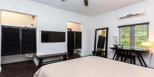 a bedroom with a bed and a desk and a tv at Vive Zen Queen Room in Miami