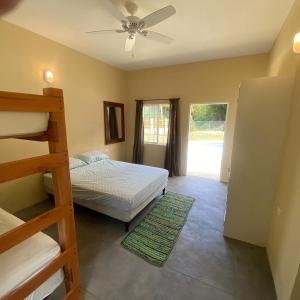 a bedroom with a bunk bed and a ceiling fan at Easy Breezy in Blanchisseuse