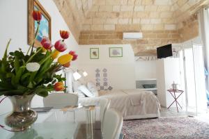 a living room with a vase of flowers on a glass table at Bed & Breakfast Al Borgo in Gioia del Colle