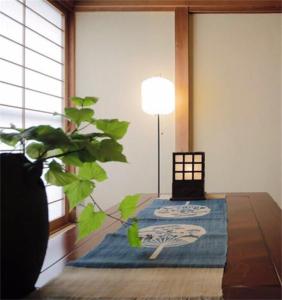 a room with a table with a plant and a lamp at Osaka MISAKI Traditional Japanese house 2-6 ppl near station in Osaka