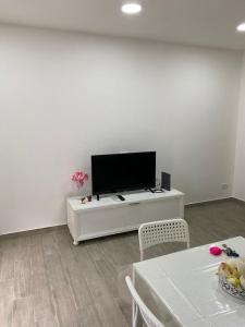 ein Wohnzimmer mit einem Flachbild-TV an einer weißen Wand in der Unterkunft House San Gennaro in Neapel
