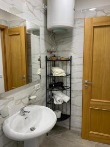 ein Badezimmer mit einem Waschbecken und einem Regal mit Handtüchern in der Unterkunft House San Gennaro in Neapel