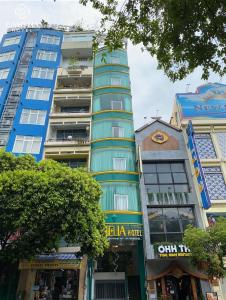 a tall blue building in a city with buildings at Camelia 108 Le Lai Hotel in Ho Chi Minh City