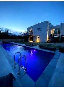 a swimming pool in front of a house at night at Le Pilotis in Gujan-Mestras