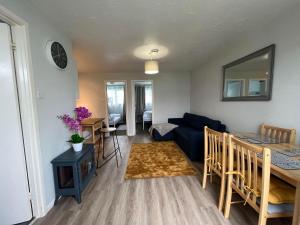 a living room with a blue couch and a table at 82, Belle Aire, Hemsby - Two bed chalet, sleeps 5, bed linen and towels included - pet friendly in Great Yarmouth