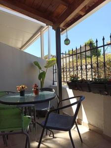patio ze stołem, krzesłami i ogrodzeniem w obiekcie Ventus w mieście Afionas