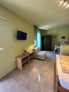 a living room with a couch and a tv on the wall at APARTMA JURICICH in Portorož