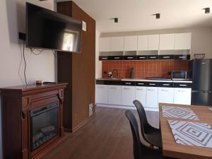 a kitchen with a fireplace and a table with chairs at Sielski Zakątek in Srokowo