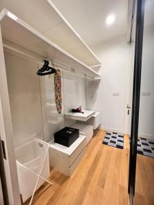 een kamer met witte kasten en een keuken met houten vloeren bij Platinum Suites KLCC in Kuala Lumpur