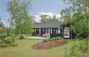 een klein zwart huis met een tuin bij Beautiful Home In Sjllands Odde With Kitchen in Yderby
