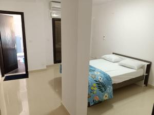 Appartement Yoff Virage vue panoramique sur mer في داكار: سرير في غرفة بيضاء مع مرآة