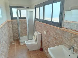 a bathroom with a shower and a toilet and a sink at Appartement Yoff Virage vue panoramique sur mer in Dakar