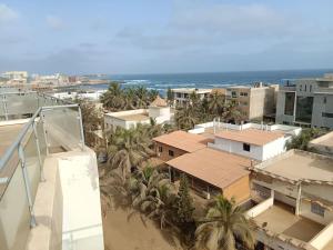 Appartement Yoff Virage vue panoramique sur mer في داكار: اطلالة جوية على مدينة فيها نخيل والمحيط
