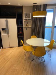 d'une salle à manger avec une table, des chaises et un réfrigérateur. dans l'établissement Studio no Hotel Bristol 500 - Bairro Batel, à Curitiba