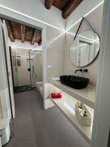 uma casa de banho com um lavatório preto e um espelho em City Fun em Rovigo