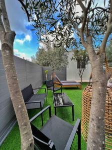 a patio with chairs and a table and a tree at The Home Away from Home with Hot Tub in Lampi