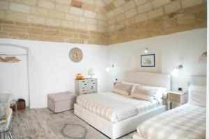 ジョーイア・デル・コッレにあるBed & Breakfast Al Borgoのレンガの壁、ベッド2台が備わるベッドルーム1室が備わります。