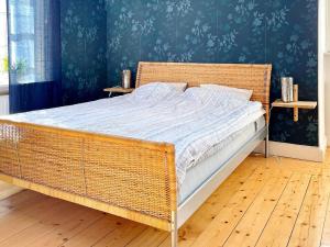 a wicker bed in a bedroom with a blue wall at 9 person holiday home in Mörlunda-By Traum in Mörlunda