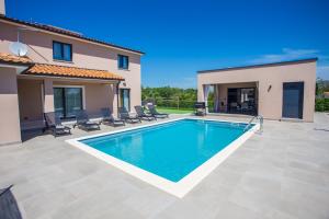 a swimming pool in front of a house at Villa Silvano & Nadija in Kaštelir