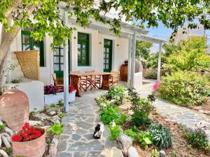 a patio with a table and a cat sitting in the yard at Nikiforos Boutique apartment in Naxos Chora