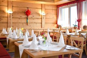 un comedor con mesas con servilletas blancas. en Burg Hotel Feldberg en Feldberg