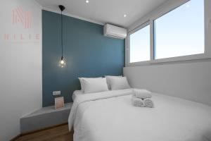 塞薩羅尼基的住宿－V1 Penthouse, Nilie Hospitality MGMT，卧室配有白色的床和窗户。