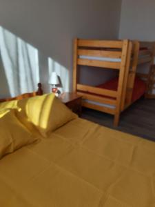 um quarto com uma cama amarela e uma cadeira em Vacances à la Tranche sur Mer em La Tranche-sur-Mer