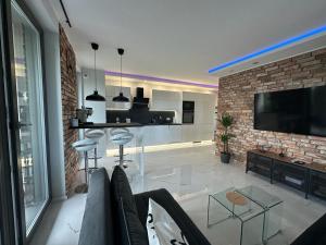 a living room with a tv and a brick wall at Apartament Centrum II in Bydgoszcz