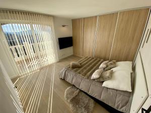 een slaapkamer met een bed en een groot raam bij Le loft des mimosas proche de cannes in La Roquette-sur-Siagne