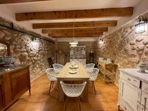 a kitchen with stone walls and a table and chairs at Casa Rural El Molí - Penáguila in Penáguila