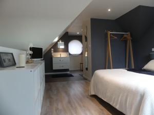- une chambre avec un lit blanc et un mur noir dans l'établissement Espace Acu-Nature, à Saint-Évarzec