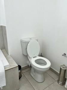 a bathroom with a white toilet in a room at Sophiscated Upmarket One Bedroom Apartment in Johannesburg +11 photos