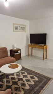 a living room with a couch and a tv at Le Pilotis in Gujan-Mestras