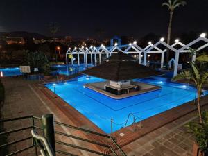 a swimming pool at night with blue lights in it at BenalSun 100 meters from Beach in Benalmádena