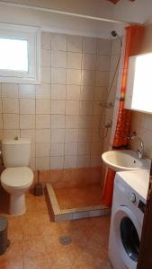 ein Badezimmer mit einem WC, einem Waschbecken und einer Waschmaschine in der Unterkunft FOUR INDEPENDENCE HOUSES BY THE SEA in Glífa