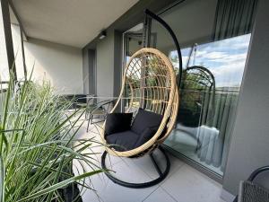 une chaise en osier assise sur un balcon dans l'établissement Apartament Centrum II, à Bydgoszcz