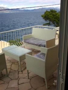 a balcony with a table and chairs and the water at Villa Teodora in Donja Vrućica