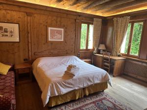 ein Schlafzimmer mit einem Bett in einem Zimmer mit Holzwänden in der Unterkunft Nogherazza - La Locanda in Belluno