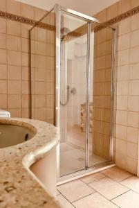 een douche met een glazen deur in de badkamer bij Golden Age in Ferrara