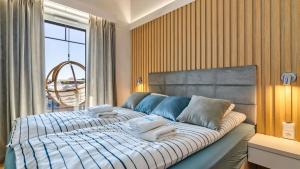 PORT KRYNICA Apartamenty في كرينيتا مورسكا: غرفة نوم بسرير كبير عليها منشفتين